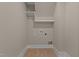 Compact laundry area with hookups and storage shelves at 418 S Cross St, Youngsville, NC 27596