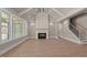Bright living room featuring wood floors, a fireplace, and a cathedral ceiling with exposed beams at 418 S Cross St, Youngsville, NC 27596