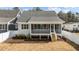 View of the rear exterior of the home, showcasing a covered porch with stairs and an open backyard space at 418 S Cross St, Youngsville, NC 27596