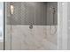 Close up of walk-in shower featuring herringbone tile, marble tile, and a built-in bench at 418 S Cross St, Youngsville, NC 27596