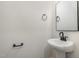 Stylish half bathroom with pedestal sink, sleek black fixtures, and modern mirror at 50 N Rowsham Pl, Smithfield, NC 27577