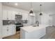 Well-lit kitchen features white cabinets, modern appliances, and an island with a breakfast bar at 50 N Rowsham Pl, Smithfield, NC 27577