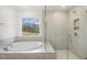 Elegant bathroom featuring a soaking tub and a tiled glass-enclosed shower with a niche at 611 Highview Dr, Benson, NC 27504