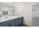 Modern bathroom featuring a double vanity with grey cabinets and a large mirror at 611 Highview Dr, Benson, NC 27504
