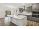Open concept kitchen with a large island, stainless hood, recessed lighting, and gray cabinetry at 611 Highview Dr, Benson, NC 27504