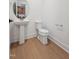 Bathroom featuring toilet, hardwood floors, white walls, and a pedestal sink at 810 Barlow Dr, Knightdale, NC 27545