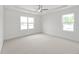 Bright bedroom with carpet, ceiling fan, and plenty of natural light from two windows at 810 Barlow Dr, Knightdale, NC 27545