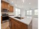 Close-up of a kitchen island with quartz countertops, stainless steel faucet, and pendant lighting at 810 Barlow Dr, Knightdale, NC 27545