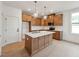 Modern kitchen featuring a center island, white backsplash, stainless steel appliances, and wooden cabinets at 810 Barlow Dr, Knightdale, NC 27545