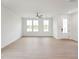 Bright, open living space with hardwood floors, large windows, and a modern ceiling fan at 810 Barlow Dr, Knightdale, NC 27545