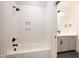Bathroom with white subway tile tub and shower, a gray vanity, and black fixtures at 8624 Dukes Lake Rd, Zebulon, NC 27597