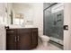 Elegant bathroom with a glass shower, dark vanity, and stylish fixtures, blending design with practicality at 8624 Dukes Lake Rd, Zebulon, NC 27597