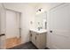 Contemporary bathroom with grey vanity, black fixtures, and a door leading to the next room at 8624 Dukes Lake Rd, Zebulon, NC 27597