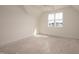 Neutral bedroom with a large window providing natural light and views of the neighborhood at 8624 Dukes Lake Rd, Zebulon, NC 27597