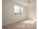 Sunlit bedroom with neutral walls, carpeted floors, a ceiling fan, and a large window at 8624 Dukes Lake Rd, Zebulon, NC 27597