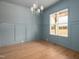 Light blue dining room featuring a large window and modern chandelier at 8624 Dukes Lake Rd, Zebulon, NC 27597