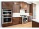 Gourmet kitchen equipped with stainless steel appliances, custom cabinetry, and quartz countertops at 8624 Dukes Lake Rd, Zebulon, NC 27597