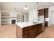 Kitchen island with stone countertops, stainless steel dishwasher, view into living room with fireplace at 8624 Dukes Lake Rd, Zebulon, NC 27597