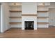 Bright living room featuring a fireplace with white tile and floating shelves at 8624 Dukes Lake Rd, Zebulon, NC 27597