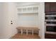 Mudroom with built-in bench seating, storage cubbies, and adjacent oven appliance at 8624 Dukes Lake Rd, Zebulon, NC 27597