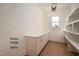 Spacious pantry features shelving, cabinets with stone countertops, and wood floors at 8624 Dukes Lake Rd, Zebulon, NC 27597