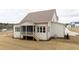 Home's back exterior view featuring a screened porch and wooden deck, great for outdoor entertaining at 8624 Dukes Lake Rd, Zebulon, NC 27597