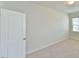 Clean bedroom featuring neutral carpet, a white door, and a window at 140 Norwell Ln, Pittsboro, NC 27312