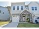 Charming two-story home featuring a stone facade, attached garage, and manicured lawn at 140 Norwell Ln, Pittsboro, NC 27312