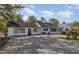 Sprawling home with a long driveway, updated white exterior, and beautifully landscaped yard at 203 W Stewart St, Coats, NC 27521