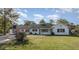 Charming single-story home with a well-maintained lawn, mature trees, and a classic white facade at 203 W Stewart St, Coats, NC 27521