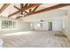 Large living room with exposed wood beams, a brick fireplace, and abundant natural light at 203 W Stewart St, Coats, NC 27521