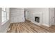 Inviting living room with hardwood floors, a painted brick fireplace, and built-in bookshelves at 203 W Stewart St, Coats, NC 27521