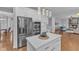 Kitchen island with stainless steel refrigerator, double oven, and open layout to the living room at 10877 Bedfordtown Dr, Raleigh, NC 27614