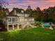 Home with large deck and pool, nestled in a wooded area at dusk at 110 Bywater Way, Chapel Hill, NC 27516