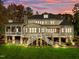 Home with large deck and stonework, nestled in a wooded area at dusk at 110 Bywater Way, Chapel Hill, NC 27516