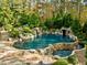 Resort-style pool and waterfall feature surrounded by lush landscaping at 110 Bywater Way, Chapel Hill, NC 27516