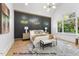 A bedroom with a paneled accent wall, king bed, nightstands, and windows at 1306 Lennox Pl, Raleigh, NC 27612