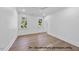 Bright bedroom with hardwood floors and multiple windows at 1306 Lennox Pl, Raleigh, NC 27612