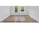 An empty room shows the hardwood floors and windows with a view of the neighborhood at 1306 Lennox Pl, Raleigh, NC 27612