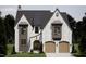 Beautiful stone home featuring a modern design, arched entry, and a symmetrical roofline at 1306 Lennox Pl, Raleigh, NC 27612