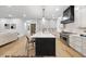 Open-concept kitchen with a large island, stainless steel appliances, and seamless access to the living area at 1306 Lennox Pl, Raleigh, NC 27612