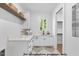Bright laundry room with white cabinets, quartz countertops, and modern fixtures at 1306 Lennox Pl, Raleigh, NC 27612