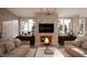 Elegant living room featuring a brick fireplace, comfortable seating, and windows with bright natural light at 1306 Lennox Pl, Raleigh, NC 27612