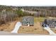 Aerial view of a green two-story home featuring a long driveway and professionally landscaped yard at 25 Basil Ct, Franklinton, NC 27525