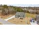 Overhead view of a green two-story home featuring a long driveway, landscaping, and wooded backdrop at 25 Basil Ct, Franklinton, NC 27525