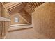 Unfinished attic space with exposed beams, wood flooring and a window at 25 Basil Ct, Franklinton, NC 27525