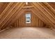 Unfinished attic space with exposed beams, wood flooring and a window at 25 Basil Ct, Franklinton, NC 27525