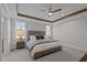 This bedroom boasts exposed wood beams, plush carpet, a ceiling fan, and two windows with a lovely wooded view at 25 Basil Ct, Franklinton, NC 27525