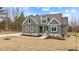 Gray farmhouse exterior with stone accents, landscaping and a partially visible driveway at 25 Basil Ct, Franklinton, NC 27525