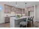 Kitchen boasts gray cabinets, a white countertop island with seating, and modern pendant lighting at 25 Basil Ct, Franklinton, NC 27525